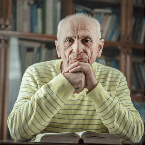 Older man in a striped sweater seated with an open book