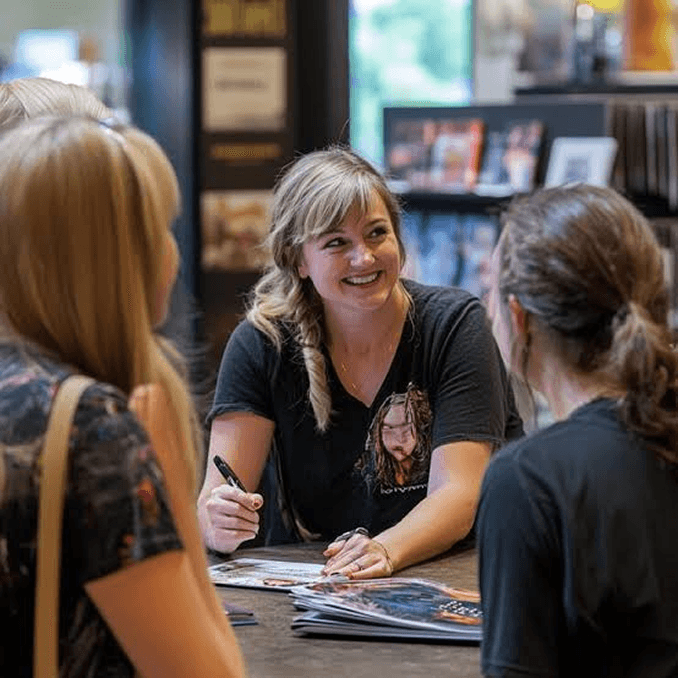 Readers browsing books with an author at a signing table