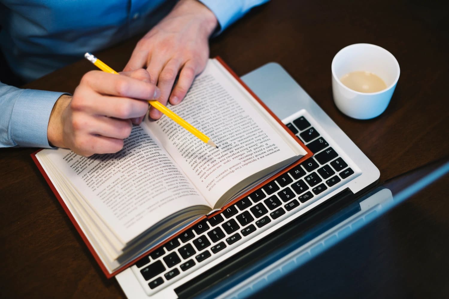 Editor reviewing a printed manuscript with a pen